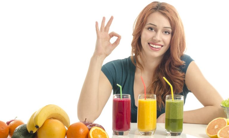 Junge Frau mit 3 Smoothies und Obst vor sich. Du hast Spaß am Thema gesunde Ernährung? Dann schau dir deine Möglichkeiten genauer an.