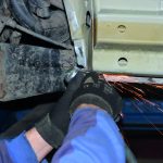 Mann arbeitet mit einer Flex an einer Karosserie. Autos sind deine Leidenschaft? Dann werde Karosserie- und Fahrzeugbaumechaniker/in.