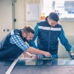 2 Männer schneiden eine Glasplatte. Glaser sind, unabhängig in welcher Fachrichtung sie sich befinden, in einer vielfältigen Auswahl verschiedener Branchen einsetzbar. Beruf: Glaser/in